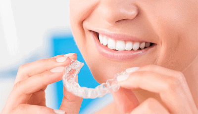 patient putting invisalign aligners in her mouth